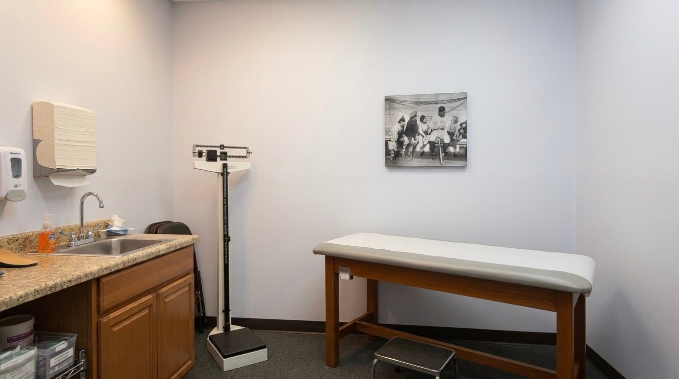 Fitting room with an exam table, a height-and-weight scale, and a sink